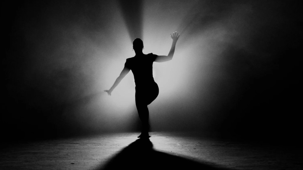 Fekete-fehér sziluett, háttérben fénysugarak — a személy helyett a mintázat és a mozgás (nem típus, hanem rendszer)